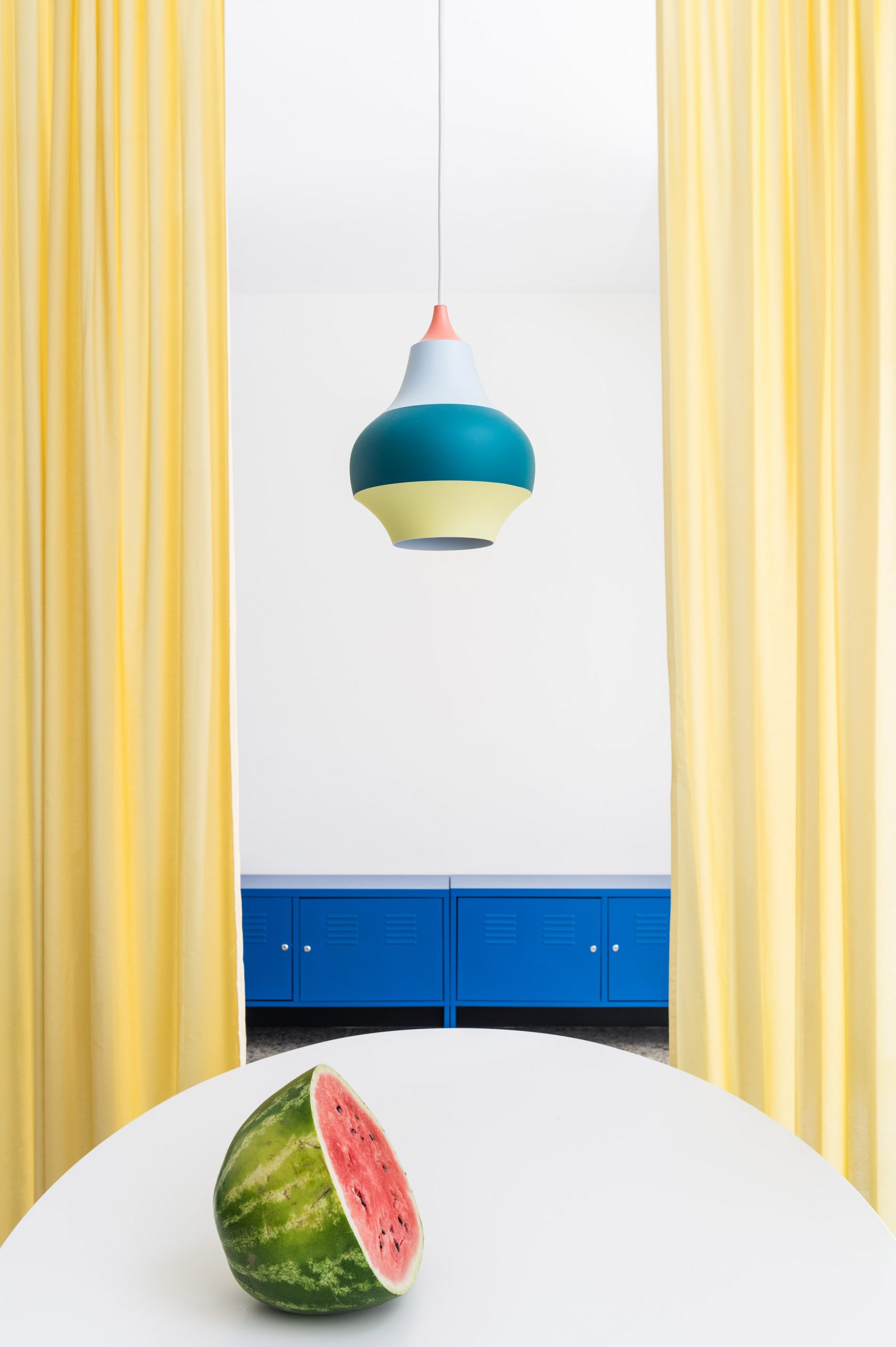 Draped yellow curtains frame the dining area