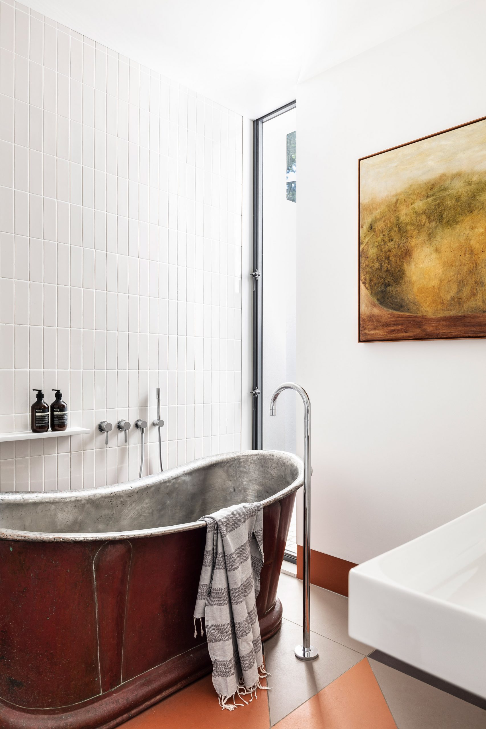Metal bath in tiled bathroom
