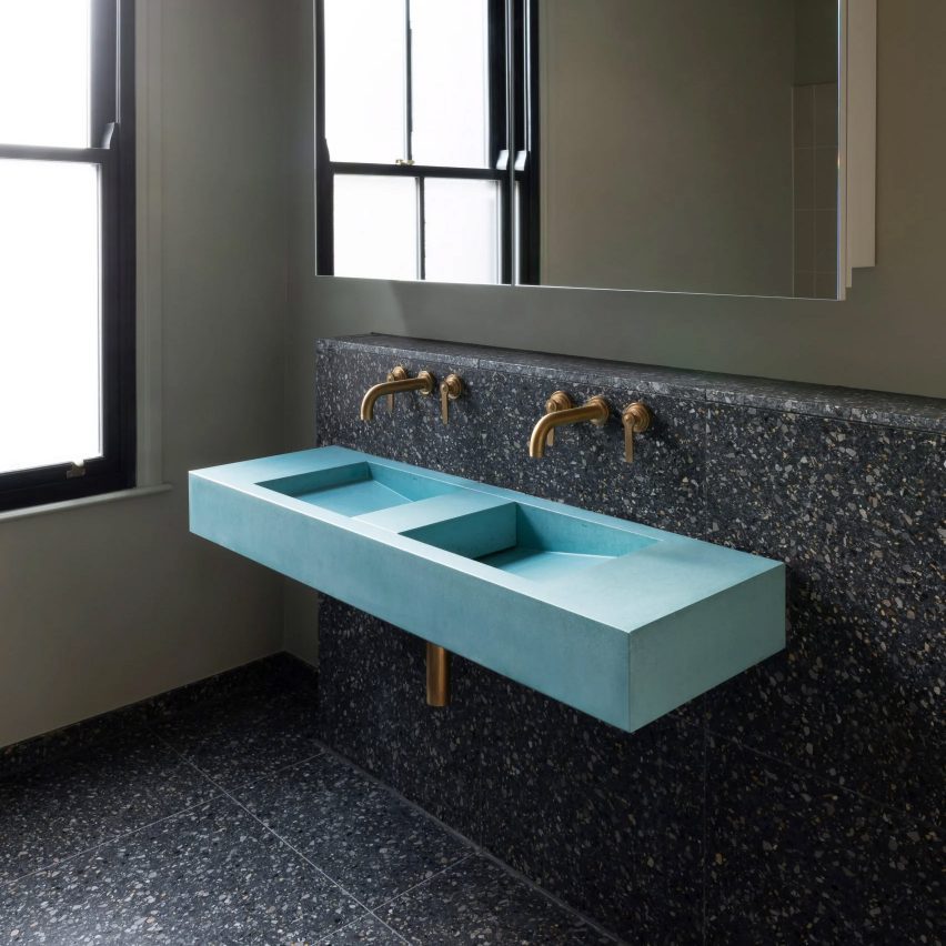 Turquoise sink against dark wall