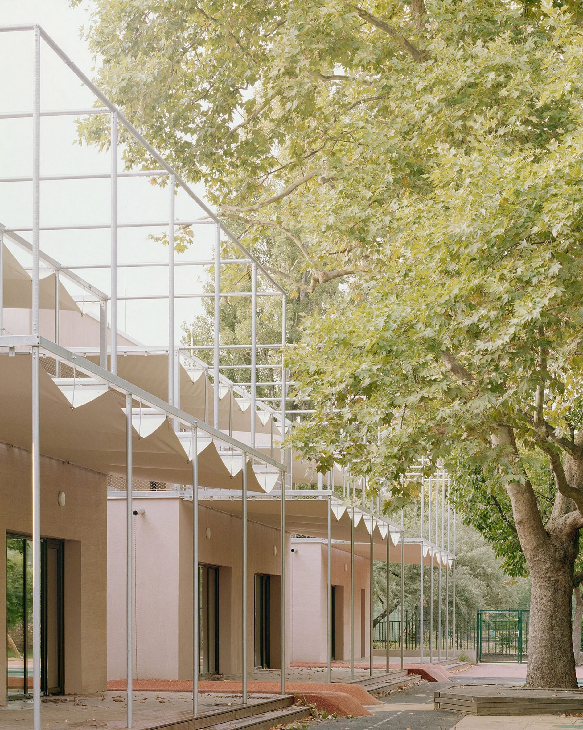 Metal canopies line nursery by Archikon