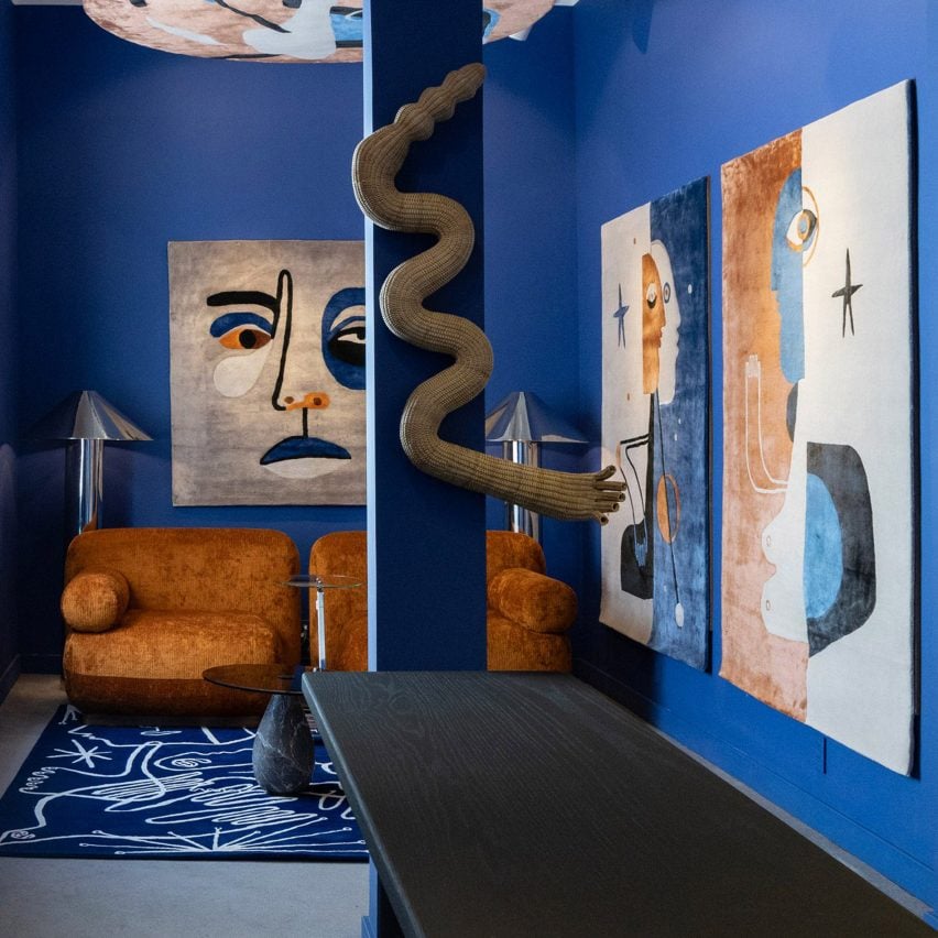 Photo of a living space with blue walls and rust-coloured art and sofa